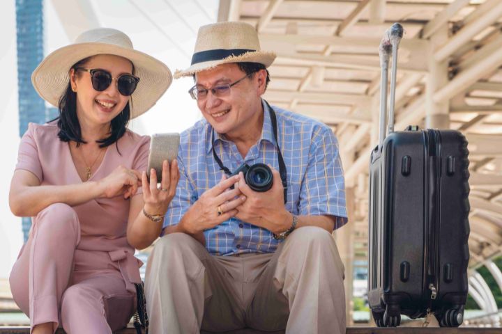 Couple holding a camera while travelling on dialysis