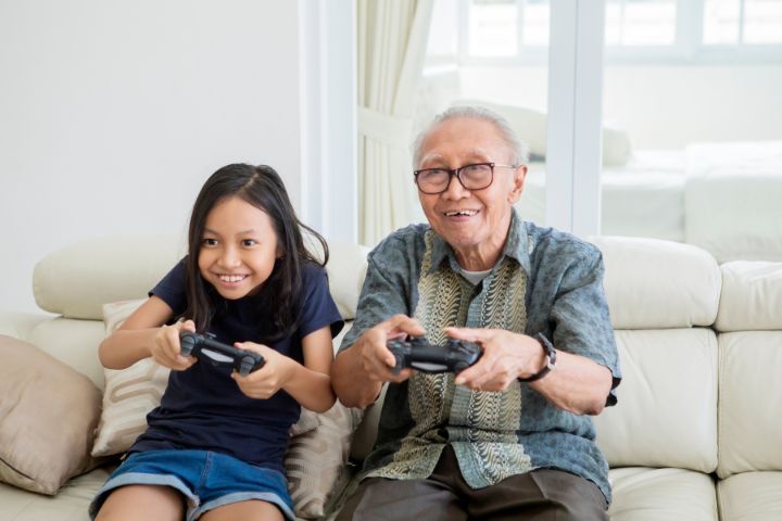 Elderly on dialysis playing video game with granddaughter
