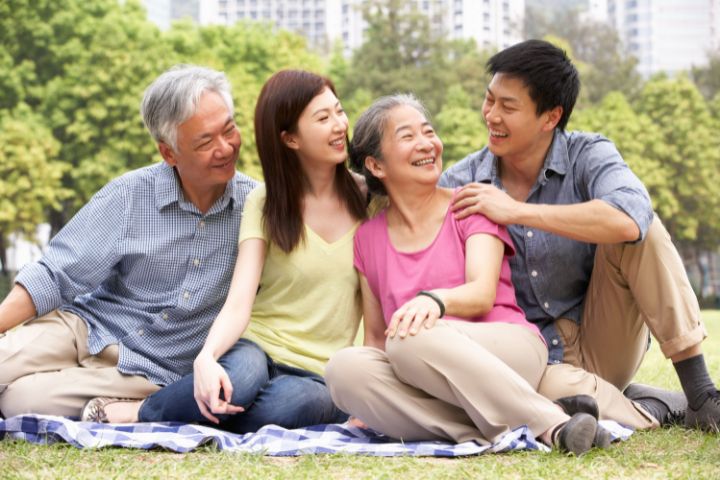Family sitting on an open field talking about dialysis