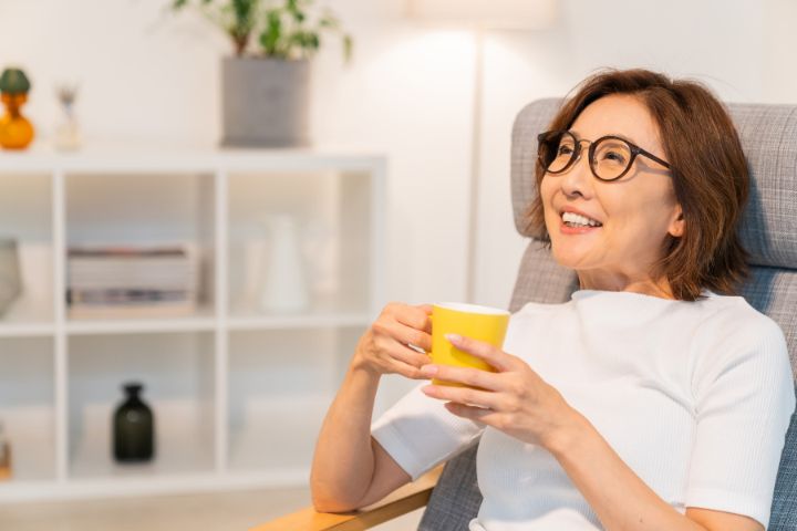 Lady on dialysis holding a mug and drinking
